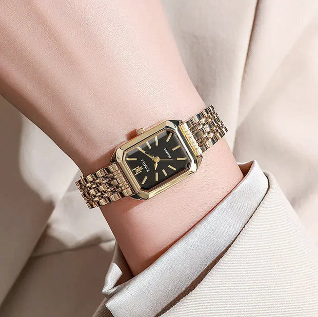 Montre pour femme, cadran carré, bracelet en acier doré, design élégant et minimaliste.