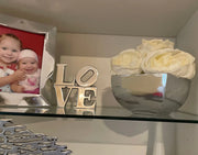 Accessoire déco moderne avec un cadre photo argenté et un bol décoratif avec des roses blanches