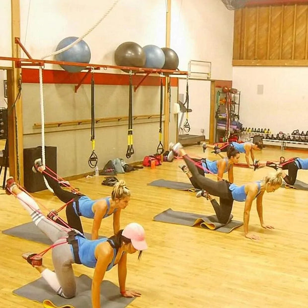 Exercice en groupe utilisant des bandes de résistance fitness dans une salle de sport moderne