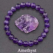 Bracelet pierre améthyste rond accompagné d'un cristal d'améthyste brut sur fond sombre