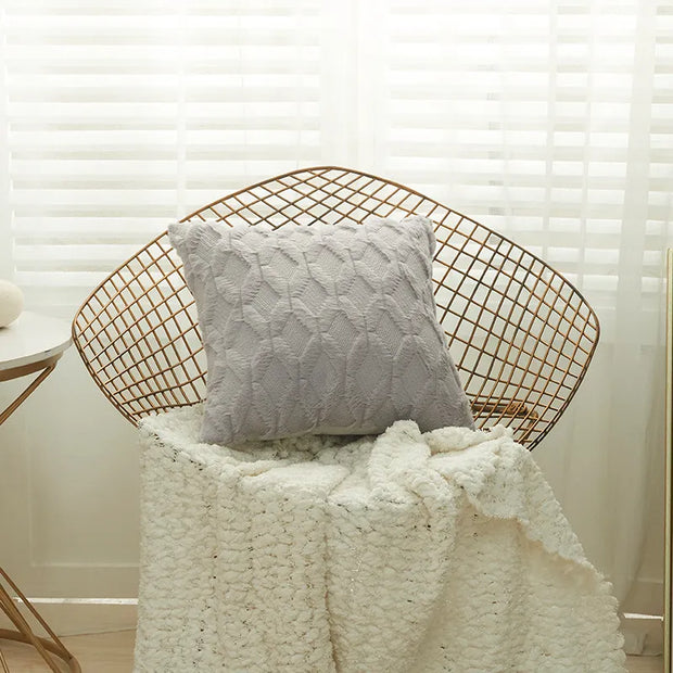 Housse coussin fourrure grise sur un fauteuil, ajoutant une touche cosy à la décoration intérieure