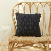 Housse coussin fourrure noire avec motif en relief sur un canapé en osier