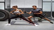 Couple faisant de l'exercice avec un kit bandes résistance entraînement dans une salle de sport moderne