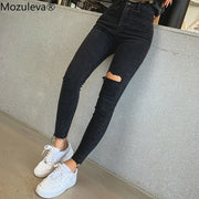Jean skinny noir femme avec déchirures et coupes modernes, idéal pour un look tendance
