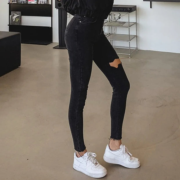 Jean skinny noir femme avec déchirures et coupe moderne pour un style tendance