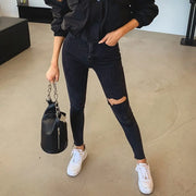Jean skinny noir femme avec déchirure, parfait pour un look décontracté et moderne