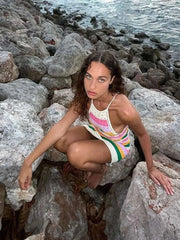 Modèle posant sur des rochers près de l'eau, portant une robe multicolore chic à bandes vibrantes