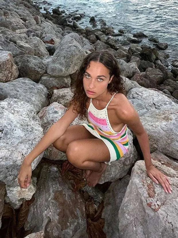 Modèle posant sur des rochers près de l'eau, portant une robe multicolore chic à bandes vibrantes