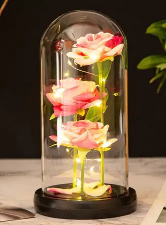 Roses sous cloche verre illuminées avec un socle en bois, décoration élégante pour intérieur