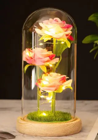 Trois roses sous cloche verre avec éclairage LED sur un socle en bois décoratif