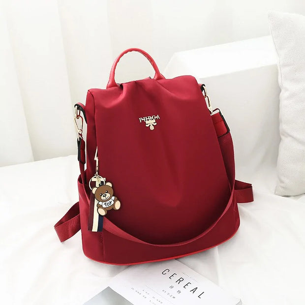 Waterproof women's Oxford backpack, red color, adjustable straps, and multiple compartments.