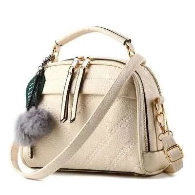 Sac à main cuir tendance beige avec pompon et bandoulière réglable pour un style chic