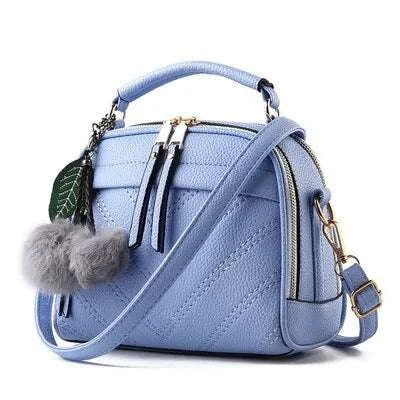Sac à main cuir tendance en bleu avec pompon et bandoulière réglable pour un style chic