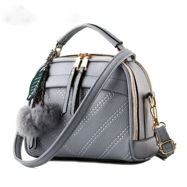 Sac à main cuir tendance gris avec pompon et bandoulière pour une touche élégante