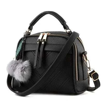 Sac à main cuir tendance noir avec pompon et bandoulière réglable, idéal pour un usage quotidien