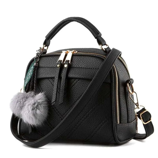 Sac à main cuir tendance noir avec pompom et bandoulière réglable pour un style chic