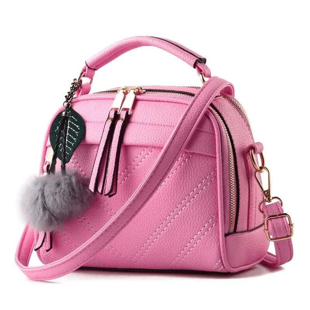 Sac à main cuir tendance rose avec pompon et bandoulière ajustable pour un look moderne
