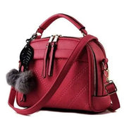 Sac à main cuir tendance rouge avec pompon et bandoulière ajustable pour un style chic