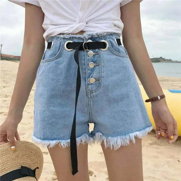 High-waisted denim shorts with belt showcasing flattering fit and stylish details on beach setting.